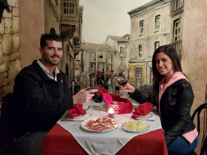 Two people on a date sitting at a table with wine.